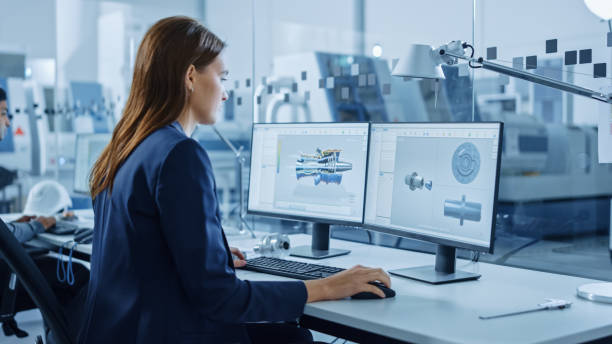 istock Portrait of Young and Confident Industrial Engineer Working on Computer, on Screen CAD Software Showing New Generation Electric Engine. Industrial Factory with High-Tech CNC Machinery. 1219894270