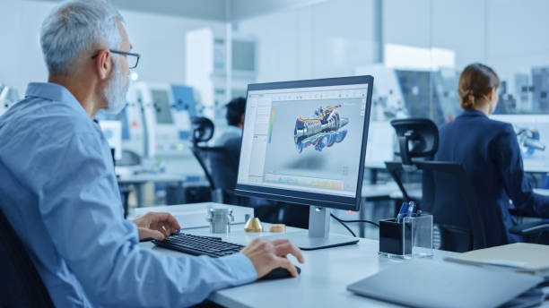 istock Modern Industrial Factory: Team of Mechanical Engineers Working on Computers, Using Newest High-Tech Devices Like Virtual Reality Headsets to Design Best Engines. 3D Graphics in Contemporary Industry 1219894274