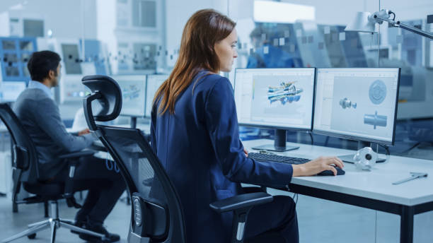 istock Over the Shoulder: Team of Mechanical Engineer Working on Personal Computers, Screens Shows CAD Software with 3D Prototype of Electric Engine, Turbine. Industrial Factory with High-Tech CNC Machinery 1219894276
