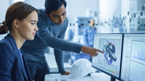 istock In Factory Workshop: Professional Workers Use High-Tech Industrial CNC Machinery, Robot Arm. Inside Office: Male Project Supervisor Talks to a Female Industry 4 Engineer who Works on Computer, Talk 1219894357