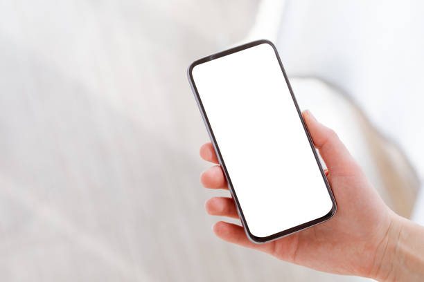 istock Mobile with white blank screen in woman hand on light background. Clipping path screen. 1219894487