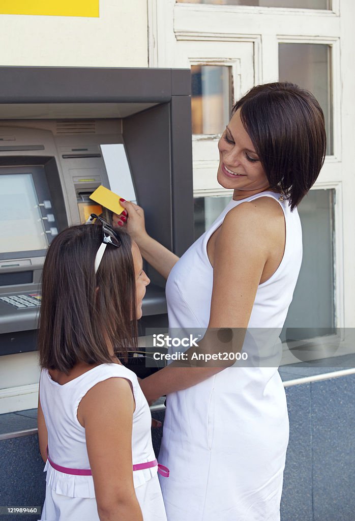 Szczęśliwa Rodzina wycofywanie pieniędzy z karty kredytowej w bankomacie - Zbiór zdjęć royalty-free (Rodzina)
