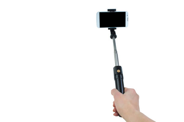 istock taking selfie - hand hold monopod with mobile phone. 1219896242