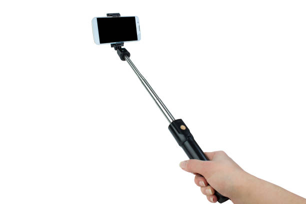istock taking selfie - hand hold monopod with mobile phone. 1219896281