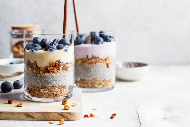 Breakfast parfait with chia, granola, berries and yogurt in a glass. Layer dessert in glass. stock photo