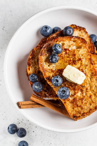 istock French toasts with berries and honey in white plate. 1219896581