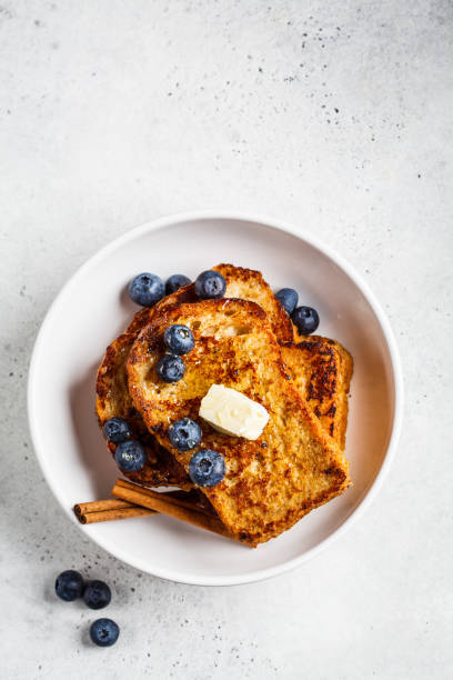 istock French toasts with berries and honey in white plate. 1219896627