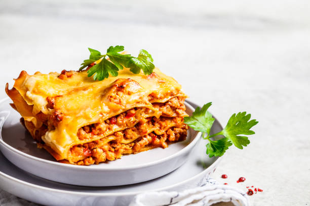 Close-up of classic meat lasagna with cheese on gray plate, copy space. Italian food concept. Close-up of classic meat lasagna with cheese on a gray plate. Italian food concept. bolognese sauce photos stock pictures, royalty-free photos & images