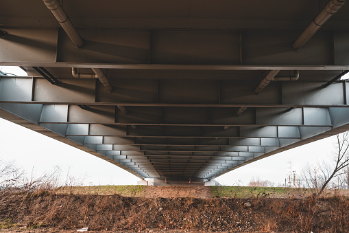 Bottom view of the road bridge structure that connects the banks of the river.