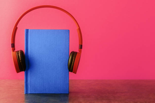 istock Notepad with headphones over pink background. Remote education concept 1219899003
