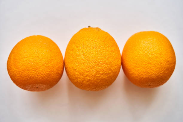 A group of oranges on a table A group of oranges on a table. Three oranges on a white background. Isolate valencia orange photos stock pictures, royalty-free photos & images