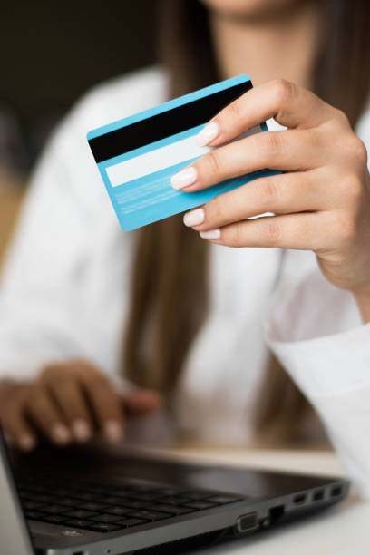 Unrecognizable female Purchasing items for the office online with credit card stock photo