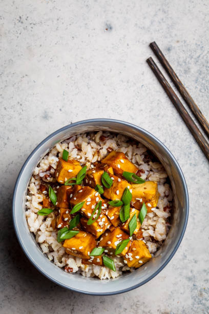 tofu marinado con semillas de sésamo, cebolla sofaina y arroz integral, vista superior. concepto de comida asiática. - brown rice fotos fotografías e imágenes de stock