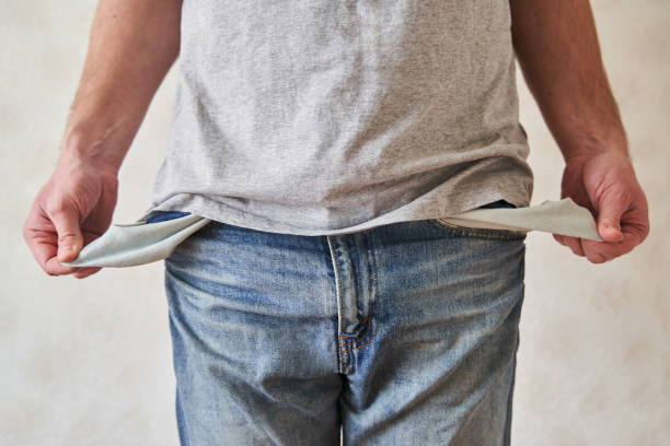 istock Inverted empty pockets. The young man turned out empty jeans pockets 1219903181