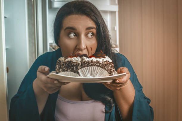 istock Body Positive Woman Eating Chocolate Dessert In Kitchen 1219904010
