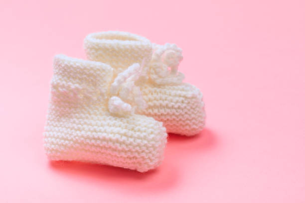 istock knitted baby booties on pastel pink background - Image 1219904145