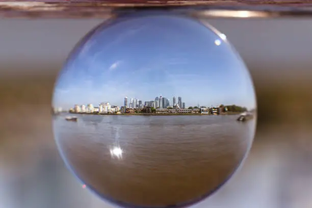 Famous modern city - London in small glass ball with Thames river. Whole huge city in 10 centimetre big ball. View on Thames river, Canary wharf, Isle of dogs, Millwall and more.