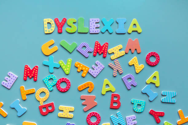 Dyslexia word written of wooden letters and scattered letters below stock photo