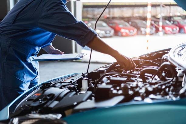 Car mechanic holding clipboard and checking to maintenance vehicle by customer claim order in auto repair shop garage. Engine repair service. People occupation and business job. Automobile technician Car mechanic holding clipboard and checking to maintenance vehicle by customer claim order in auto repair shop garage. Engine repair service. People occupation and business job. Automobile technician land vehicle stock pictures, royalty-free photos & images