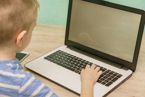 istock Distance learning online education. Schoolboy studying at home with laptop and doing school homework. 1219905663