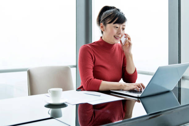 istock Woman using smart phone and laptop in office 1219907556