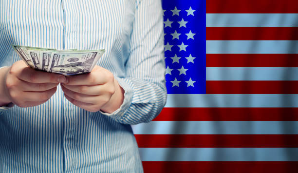 istock Hands counts money on American flag background 1219909417