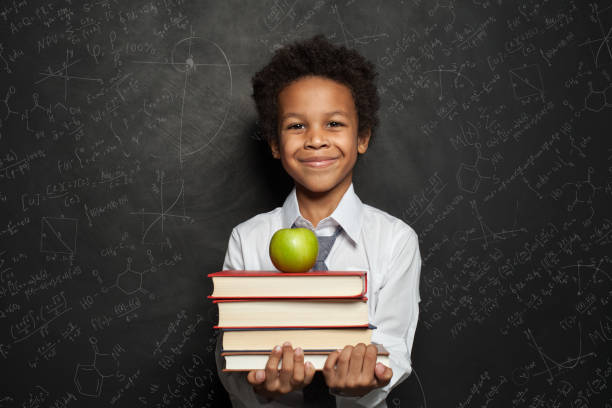 istock Little black child boy smiling and looking up on blue background 1219909788
