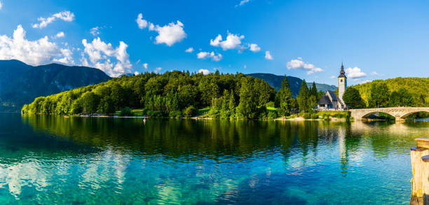 kościół "sv. janeza krstnika" nad jeziorem bohinj, w otoczeniu gór i lasu. - lake bohinj zdjęcia i obrazy z banku zdjęć