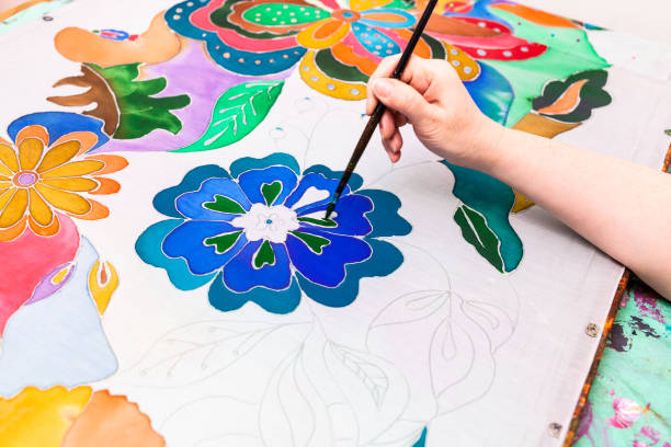 istock craftsman paints batik with floral pattern on silk 1219913085