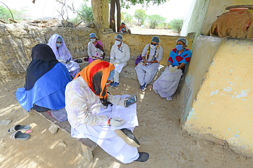 Beawar, Rajasthan, India - April 19, 2020: Anganwadi workers and medical staff wearing protective face mask at Roopnagar village during first day of curfew imposed in 28 village after COVID-19 case in Beawar.