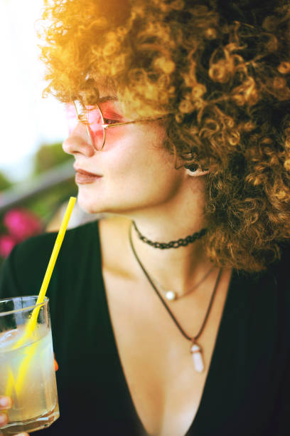 istock Young woman drinking lemonade 1219916187