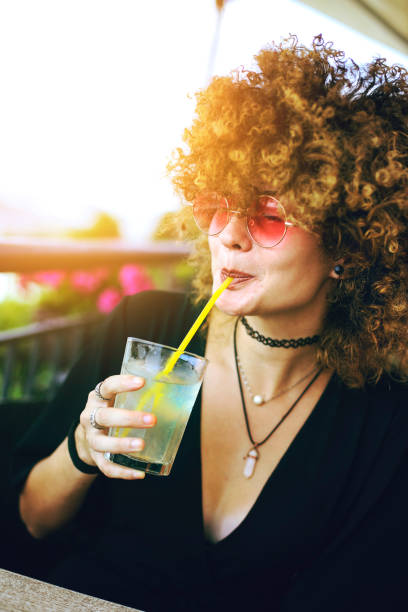 istock Young woman drinking lemonade in a bar 1219916267