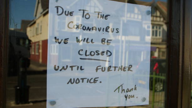 closed sign in window due to coronavirus pandemic - business closed imagens e fotografias de stock