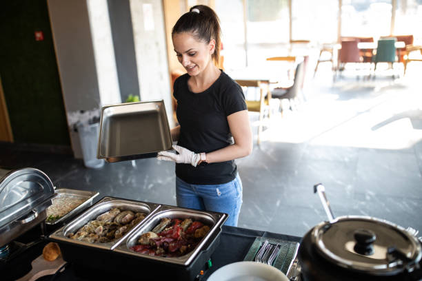 istock Caterer setting up chafing dishes with savory food during buffet preparation 1219917597