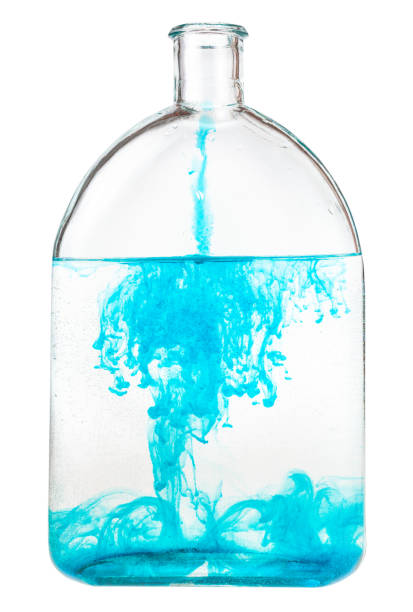istock blue watercolour dissolves in water in glass flask 1219919296