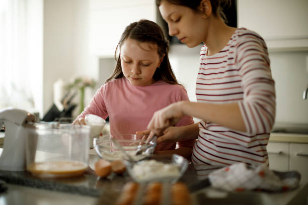 istock Sisters cooking together at home 1219920356