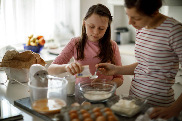 istock Sisters making cake together at home 1219920550