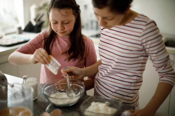 istock Sisters making cake together at home 1219920602