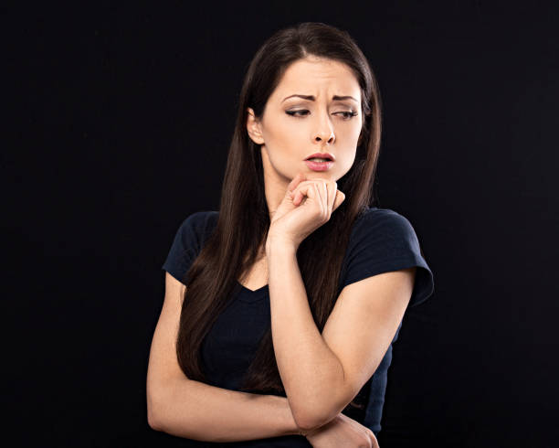 istock Very concentrated unhappy business woman looking down and find the solution on problem situation. Corona virus. Studio portrait on black background 1219920890