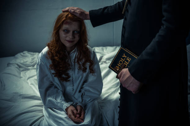 exorcist holding bible and hugging demonic creepy girl in bedroom exorcist holding bible and hugging demonic creepy girl in bedroom exorcism stock pictures, royalty-free photos & images