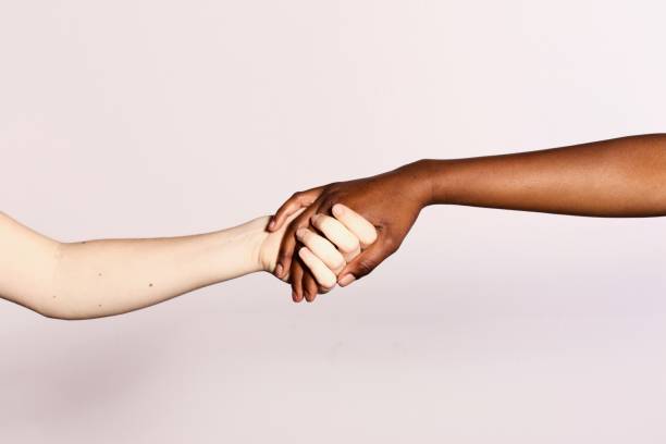istock racism concept, black and white hand holding together 1219923669