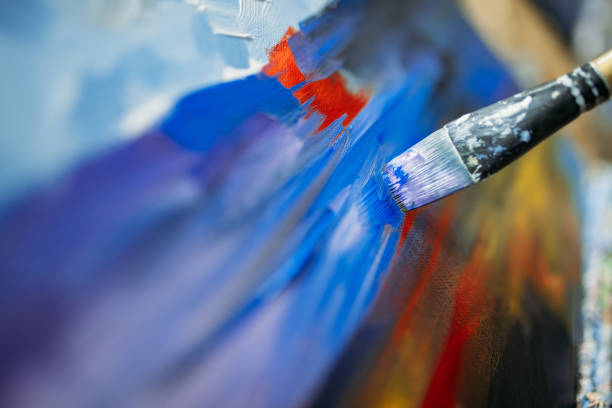 istock painting with a brush on canvas with blue paint. close-up, soft focus 1219924922