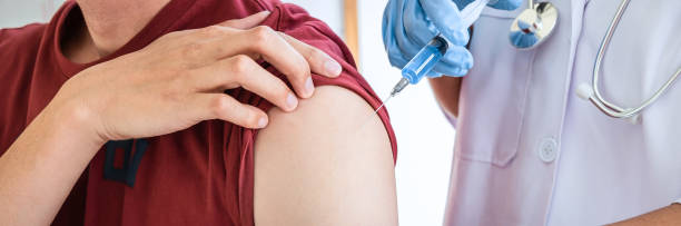 istock Doctor making a vaccination into patient with needle getting immune vaccine at arm for flu shot, coronavirus protective of epidemic 1219925557