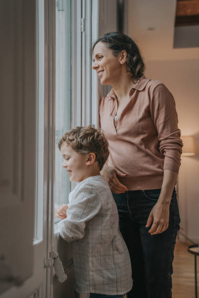 istock Mother with son looking through the window 1219926806