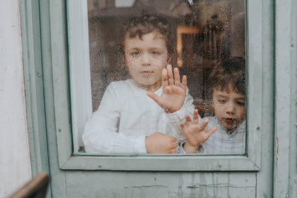 istock Brothers stay at home and looking through the window 1219926820