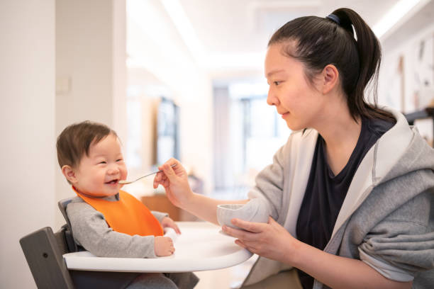 istock Young Asian mother feeding her baby son 1219927182