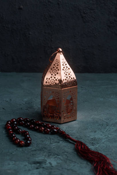 istock antique bronze copper ramadan lantern with red and black prayer beads on a navy blue concrete background 1219927476