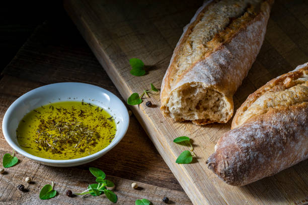 Dipping olive oil and fresh baguette. Wooden board, background. dipping stock pictures, royalty-free photos & images