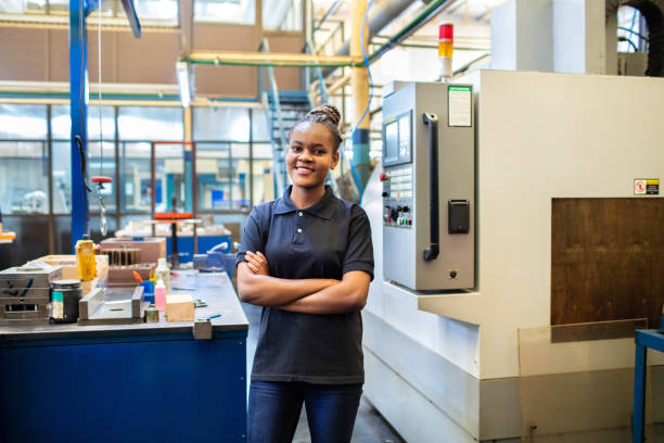 istock Happy female worker standing in factory workshop 1219928546