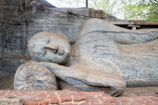 Photo of Beautiful face of reclining Buddha is 14 m long, picturing Buddha entering Nirvana at Gal Vihara in ancient city of Polonnaruwa, Sri Lanka.